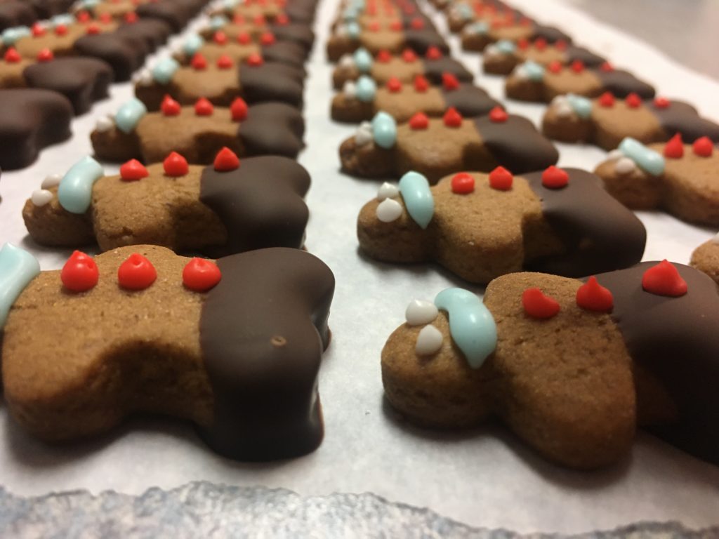 A tray of gingerbread men with icing for eyes, smiles and buttons plus chocolate pants
