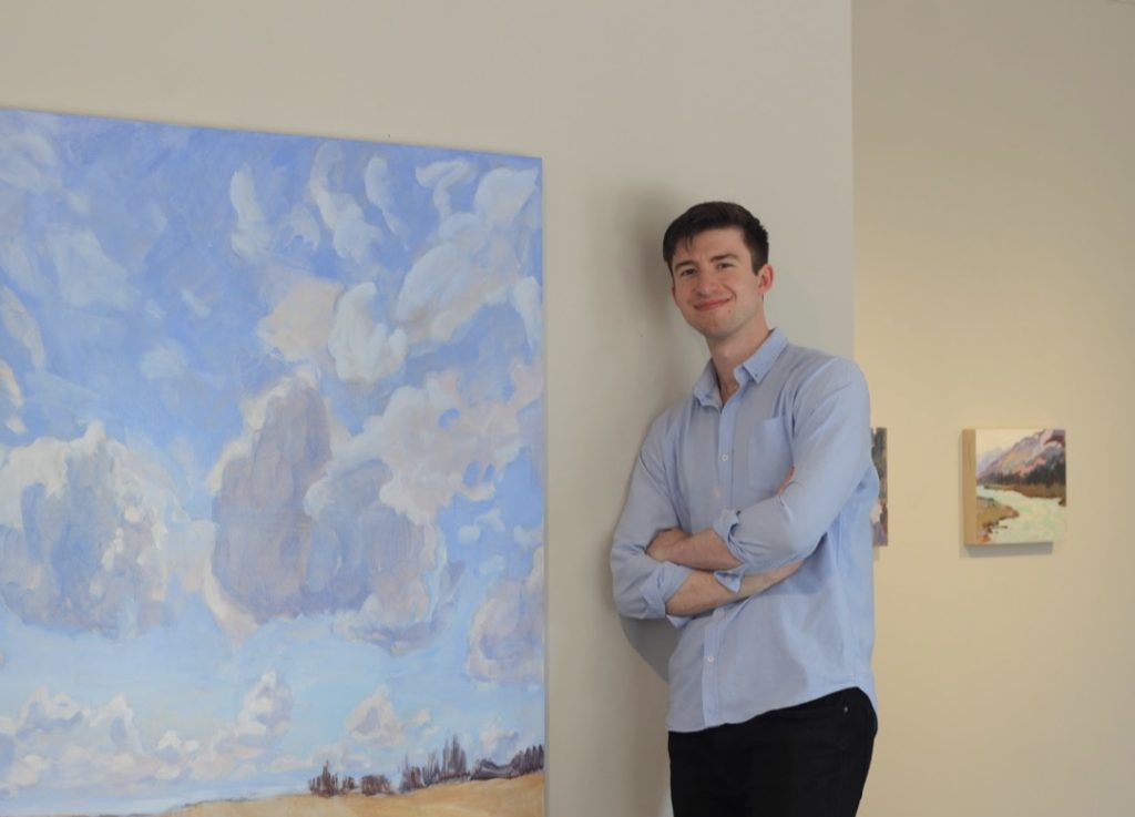 James MacDonald standing in front or his art